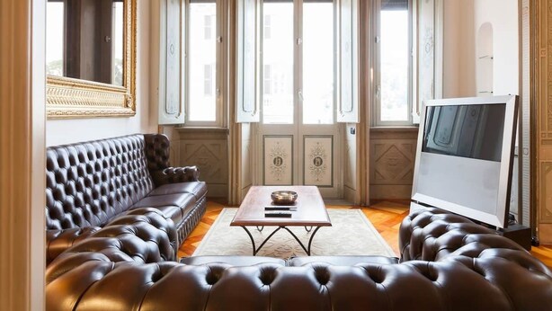 A room with a dark brown leather sofa, a wooden coffee table, and a flat-screen TV. - CHARMING APARTMENT PIAZZA DEL POPOLO, 240 m2, 4 bedrooms, 9 sleeps, 2.5 bathr, (Rome)