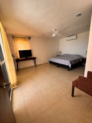 A bedroom with a bed, a desk, a TV, and a chair. - In front of the beach with power and wifi included! (CHUBURNÁ PUERTO)