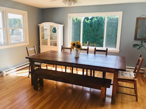 Enjoy meals in this dining room with a large table and six chairs, surrounded by a beautiful view of the lush outdoor area.