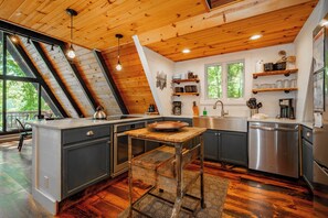 Een keuken met een houten plafond, een eettafel en uitzicht op de omgeving.