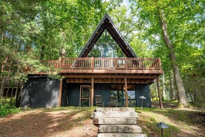 A cabin with a wooden deck and a large window.