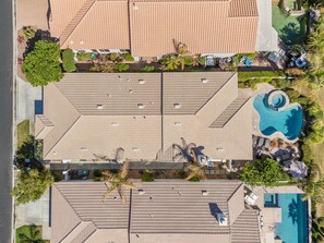 Un toit-terrasse divisé en plusieurs espaces, une piscine et une végétation luxuriante tout autour.