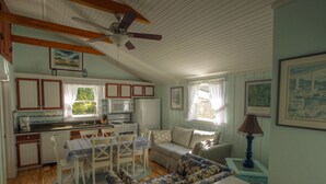 A cozy kitchen with wooden cabinets, a dining table, and a ceiling fan.