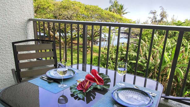 Una mesa para dos con vistas a un paisaje tropical.