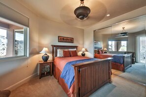 A bedroom with a large bed, two bedside tables, a mirror, and a view of the outdoors. - Private Desert Sunset Getaway (Santa Clara)