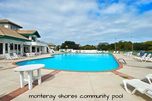 Relax by the community pool, surrounded by lounge chairs and a nearby table.