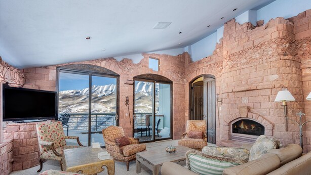 A spacious living room with a fireplace, comfortable seating, and a large TV. - Unbeatable Views in 3 Bedroom Penthouse - Great Location (Mountain Villlage)