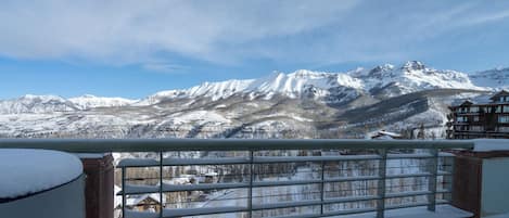 Un paisaje de montaña con picos nevados y un edificio de madera al frente.