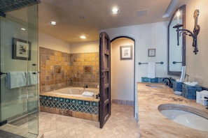 Une salle de bain dotée d’une douche à parois de verre, d’une baignoire sur pieds et d’un grand lavabo.