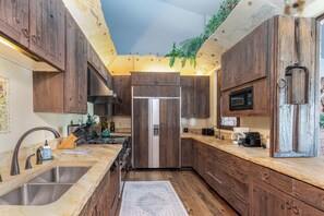 A kitchen with wooden cabinets, a stainless steel sink, and a built-in microwave.