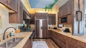A kitchen with wooden cabinets, a stainless steel sink, a microwave, and a refrigerator. - Unbeatable Views in 3 Bedroom Penthouse - Great Location (Mountain Villlage)