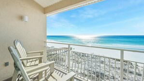 Ein Balkon mit Blick auf Strand und Meer.