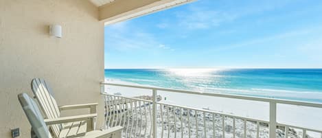 A balcony with a view of a beach and ocean.