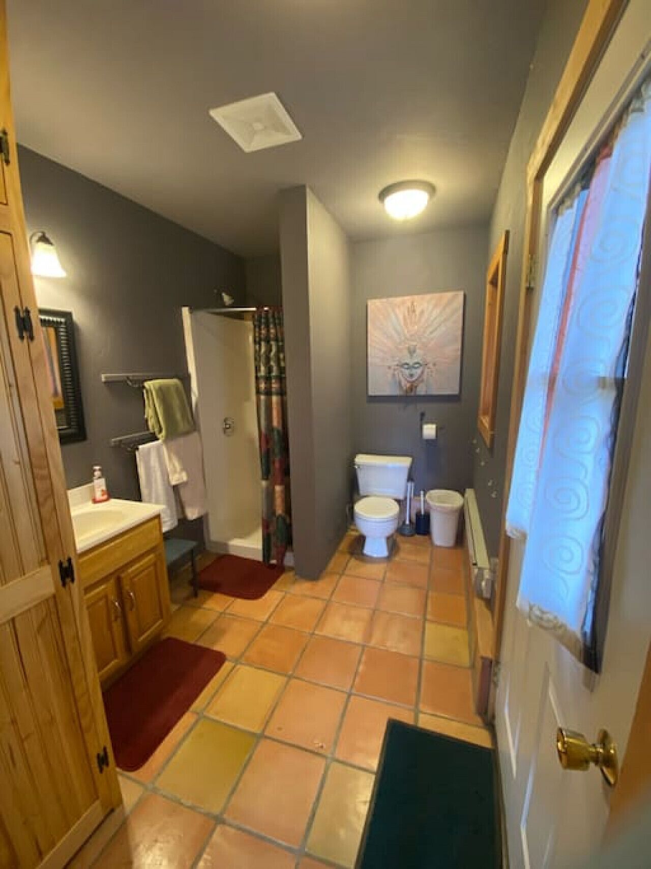 A bathroom with a toilet, sink, and shower area.