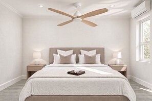 A bedroom with a bed, nightstands, a ceiling fan, and a window.
