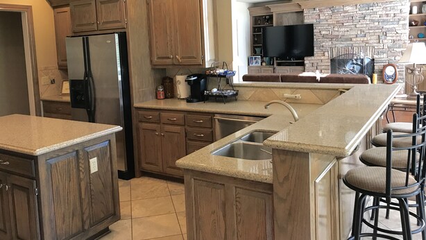 A kitchen with wooden cabinets, a stainless steel refrigerator, a built-in oven, a coffee maker, and a stone backsplash. - Gorgeous Home In Upscale Neighborhood - Room For The Whole Family 4 bedrooms! (Pawhuska)