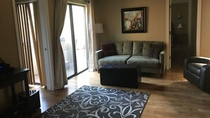Un salon avec un canapé, une table basse et un tapis à motifs.
