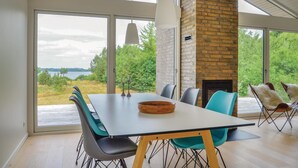 A modern dining area with a large table, chairs, and a fireplace.