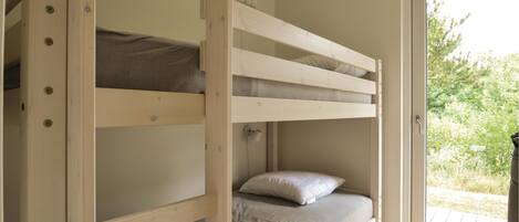 A bunk bed with a wooden frame, a grey mattress, and a white pillow.