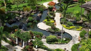 Un jardin aménagé avec un étang, des sentiers pédestres et diverses plantes.