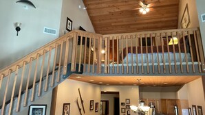 A wooden staircase leading to a loft bedroom with a bed, a ceiling fan, and framed pictures on the walls. - Deer Valley-100yds~1min walk. Closest Powder Run Penthouse. Deck Hot Tub w'Views (Park City)