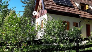 Ein Haus mit geneigtem Dach, Solaranlagen und einer Satellitenschüssel.