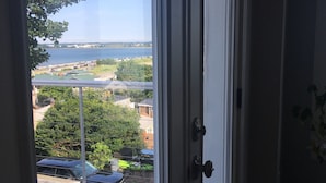 A room with a view of a body of water, a dock, and a green bicycle parked outside. - Oasis by the sea in Nahant  (Nahant)