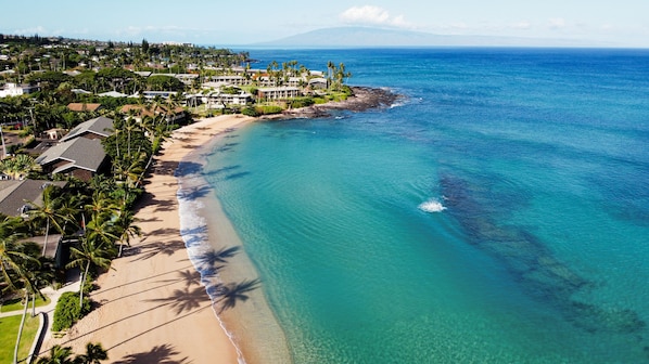 A coastal resort with beachfront properties, clear turquoise waters, and a view of the ocean.