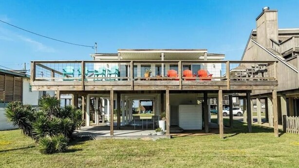 Ein zweistöckiges Haus mit Balkon, Garage und kleinem Garten.