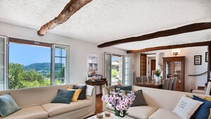 A spacious living room with two sofas, a coffee table, and a view of the outdoors. - Provencal villa located in serene setting with panoramic views, sleeps 12 (Le Bar-sur-Loup)