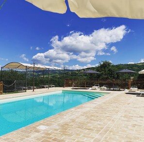 Relax by the serene pool surrounded by a well-maintained patio and picturesque views.