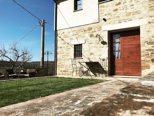 Situated on a well-maintained lawn, this traditional building offers a peaceful outdoor space with a table and chairs.