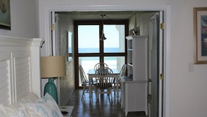 A room with a bed, a desk, and a view of the ocean. - Amazing Direct Oceanfront Condo. Steps to the Bch and Heated Pool. Gated complex (New Smyrna Beach)