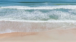 A beach with waves approaching the shore. - Amazing Direct Oceanfront Condo. Steps to the Bch and Heated Pool. Gated complex (New Smyrna Beach)