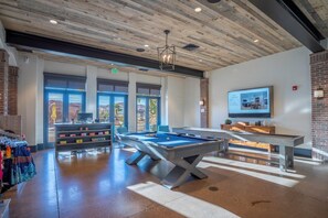 Relax and unwind in this indoor recreational area, featuring a pool table, billiards table, and TV.