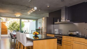 A modern kitchen with wooden cabinets, a black countertop, and stainless steel appliances.