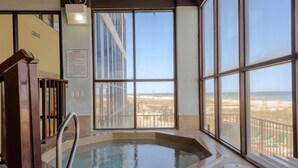 A spa area with a hot tub and large windows offering a beach view. -  Stunning Beachfront View Condo (Orange Beach)
