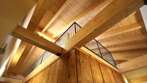 A wooden interior with a high ceiling and exposed beams.