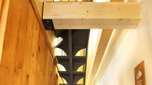 A wooden staircase with a metal railing leading to a loft area.