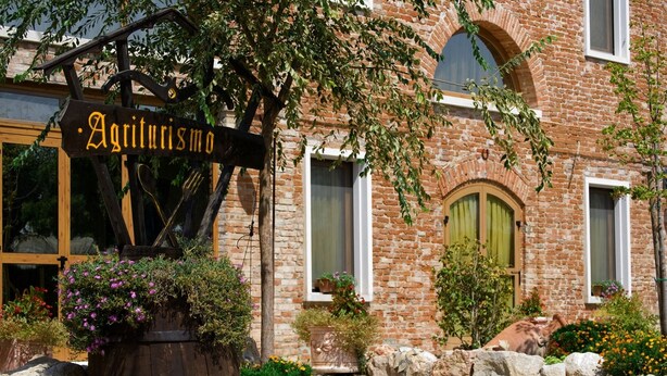 A rustic building with a sign reading "Agriturismo."