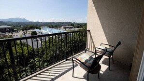 A balcony with a view of a parking lot and buildings, two chairs, and a railing. - The Cove - Unit 1302 - FREE Attraction Ticket with EACH night Stay Including Dollywood (Pigeon Forge)