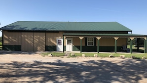 A building with a green roof and a covered porch area. - Sportsman's Paradise (Stockton)