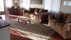 A living room with a brown sofa set, a coffee table, and a patterned rug.