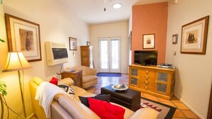 A living room with a sofa, armchair, and a television on a wooden cabinet.