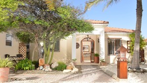 Une maison avec un patio, un cactus et un vélo.