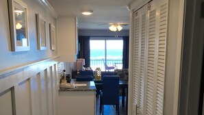 A hallway with a kitchen area, dining space, and a view of the ocean. - STUNNING GULF FRONT VIEW! (Destin)