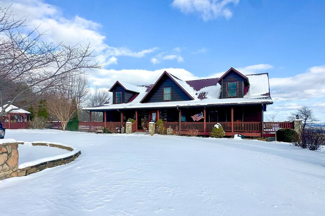 A two-story house with a snow-covered roof and a front porch.