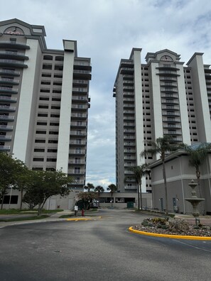 A multi-story hotel with balconies, a central courtyard, and a fountain.