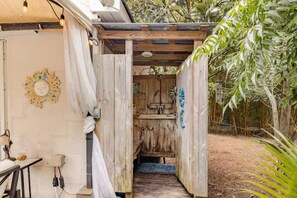 Une structure en bois comprenant un banc et une petite table, une porte en bois et un luminaire fixé au mur.