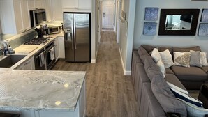 A modern kitchen with stainless steel appliances, a marble countertop, and a wooden floor. - Clean, Newly Remodeled Home Steps to  Beach, HOT TUB, LARGE deck  w/ocean peek (Santa Cruz)